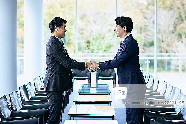 Two Businessmen Shaking Hands In An Office