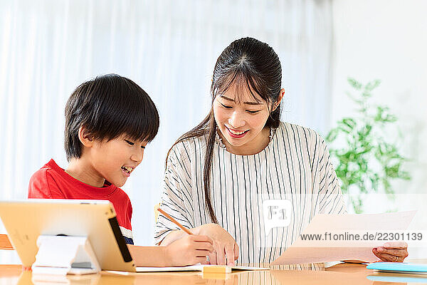 Japanese Mother And Son Doing Homework At Home