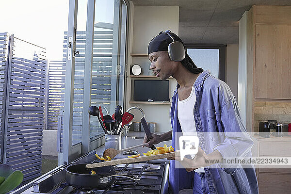 Man with headphones cooking in kitchen