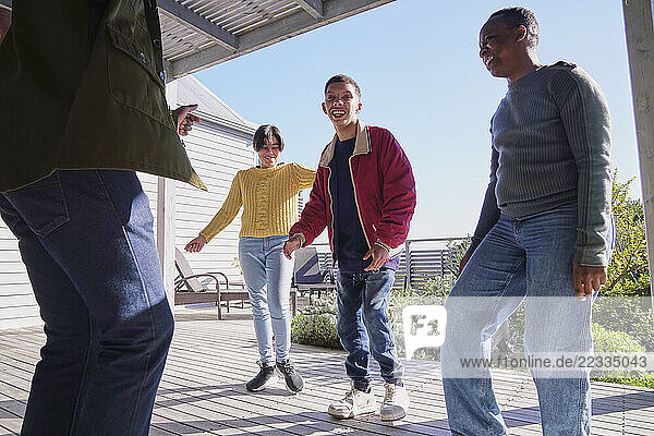 Smiling friends dancing on patio