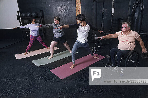 People practicing yoga in gym