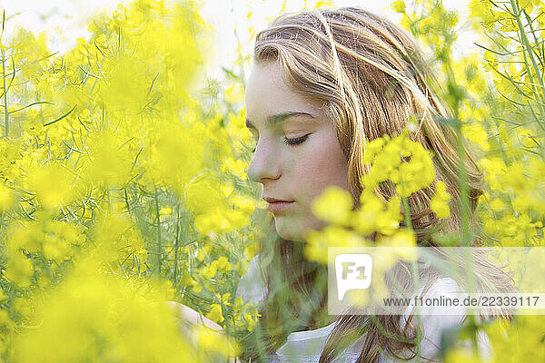 Profile of Young Woman amongst Canola Flowers