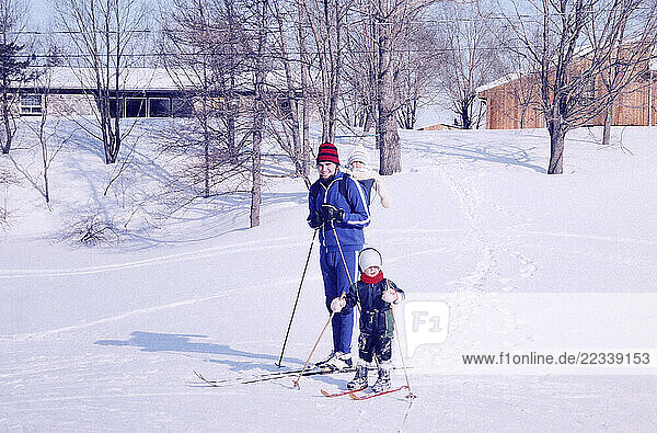 Portrait father and children cross-country skiing in snow