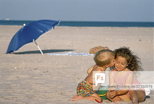 Boy and Girl in Swimwear on Beach  Boy Kissing Girl on Cheek