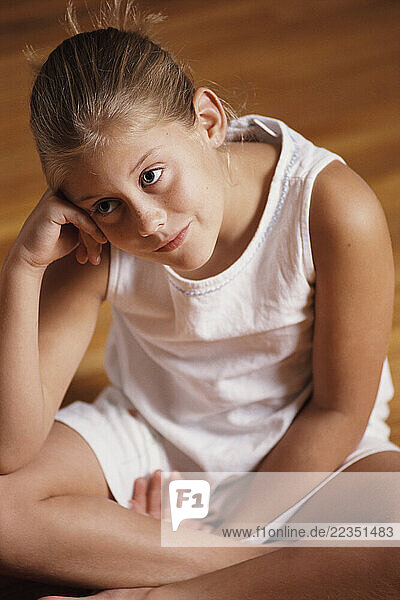 Girl Sitting on Floor  Resting Head on Hand