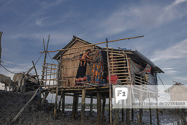 Family in front of their house is always surround by the high and low tide salt water in the Kalabogi village  close to the Sundarbans mangrove forest in Bangladesh  on 04 September 2023; Khulna  Dhaka  Bangladesh