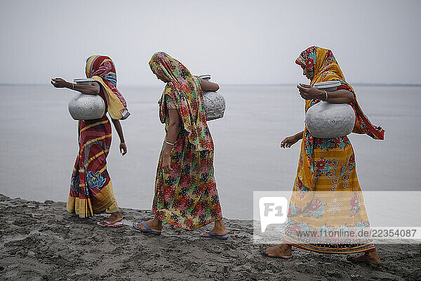 Women need to walk from their house around 1/2 kilometer to collect drinking water at the Kalabogi village in Khulna  Bangladesh  on 01 September 2023. In the coastal areas of Southern Bangladesh like Kalabogi  people‘s livelihoods depend entirely on nature. Climate change has severe impacts on the natural environment. The consequences range from rising sea levels leading to salinization of soils and groundwater to erratic rainfall patterns and more frequent and destructive tropical cyclones. People living in coastal areas fight for their survival every day; Khula  Dhaka  Bangladesh