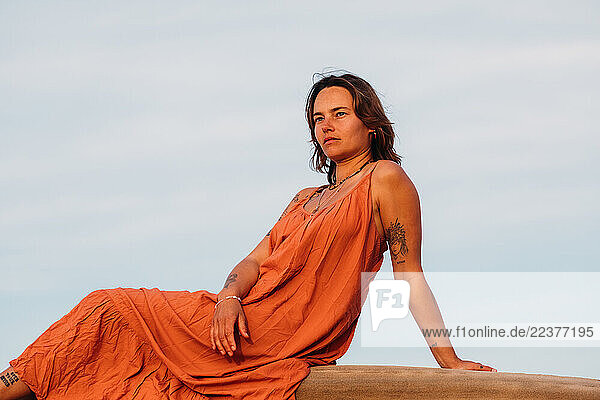 Confident woman sitting on a rock gazing into the distance