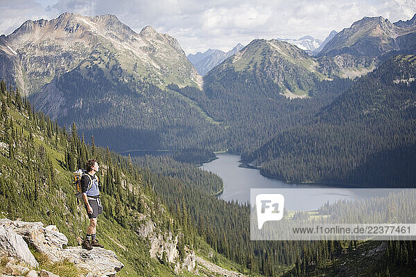 Sol Mountain  BC - Dave Fleer looks over Peters Lake while hiking from Sol Mountain Touring s lodge in the Southern Monashee range of the Columbia Mountains of South Central British Columbia. Route: 10K hike Sol Mt. Lodge NW to South Cariboo Pass east side of Mount Fosthall. Continued north to view point overlooking Cirque and Peters Lakes. Then a short doubled back before dropping via scree path into north side of Cariboo Pass. Traveled benches SE direction along north side (backside) of Mission Ridge to a pass that opened to back to the lodge side above the headpond of Sol Creek. Back to Lodge. Model/Guide: Dave Flear (53)
Asst: Lia Pulsifer (13)