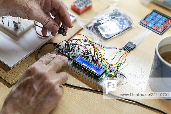 Senior man working on electronic circuits in his workshop
