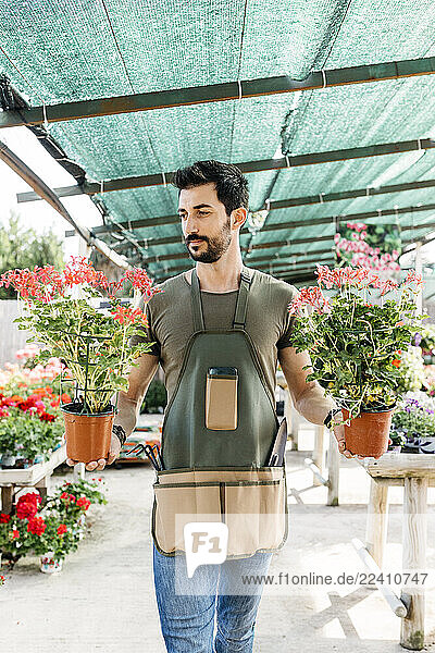 Gardener in a greenhouse holding flowers