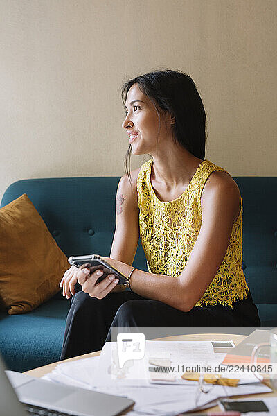 Smiling fashion designer sitting on couch having a break