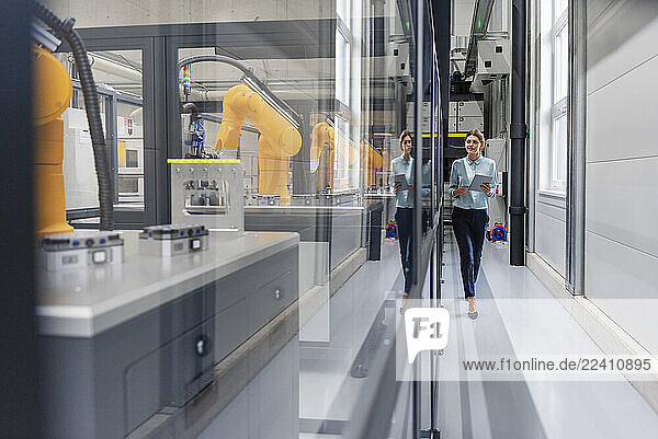 Woman in a production hall with industrial robots