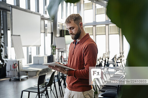 Young man using a tablet in a modern office setting