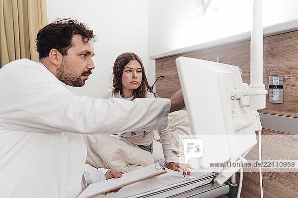 Doctor consulting with patient in a clinic using a display