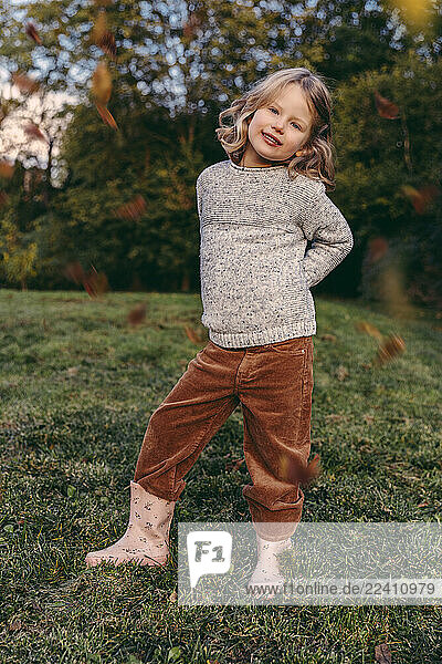 Portrait of smiling girl standing on a meadow in autumn
