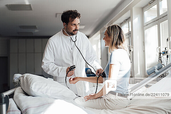Doctor checking patient s blood pressure in a clinic