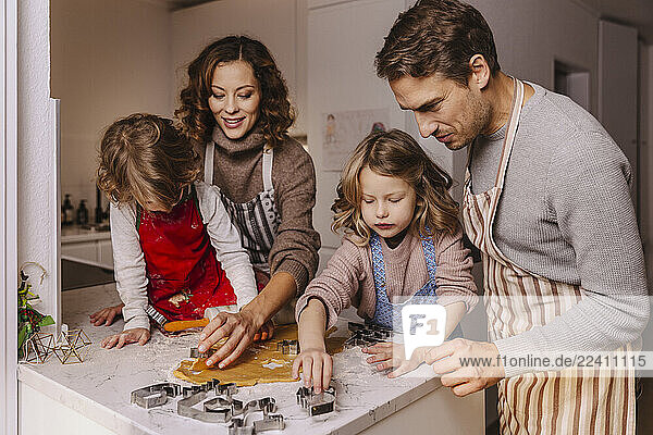 Family preparing Christmas cookies in kitchen