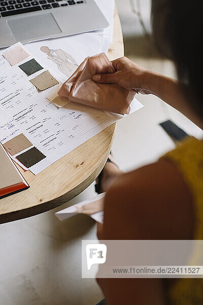 Close-up of fashion designer working on a new collection checking color samples