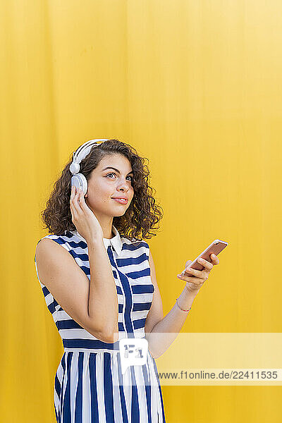 Portrait of young woman with headphones using smartphone