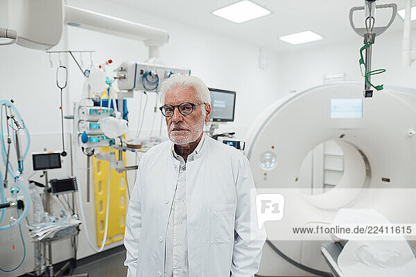 Doctor in a clinic standing next to medical equipment in an emergency room