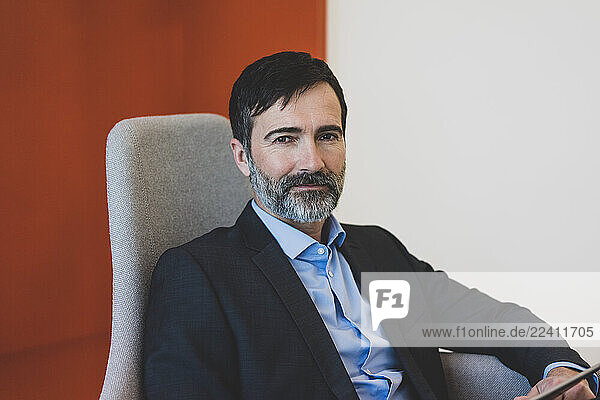 Portrait of confident mature businessman sitting in a chair