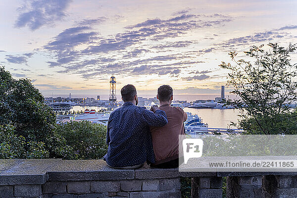 Gay couple on lookout above the city with view to the port  Barcelona  Spain