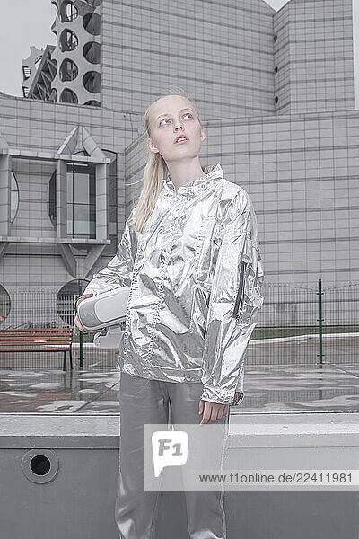 Girl in silver suit carrying VR goggles under her arm