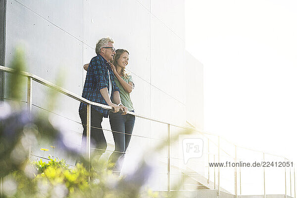 Smiling couple standing in front of their modern home