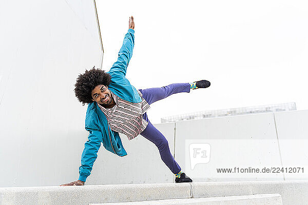 Young hipster man dancing  white wall in the background
