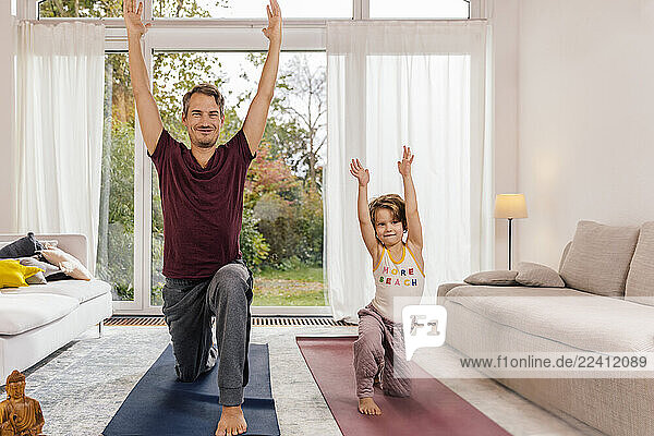 Father and daughter doing yoga together at home