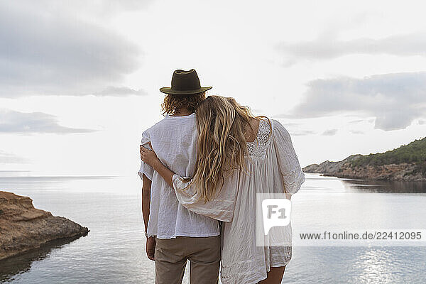 Back view of young couple in love standing in front of the sea  Ibiza  Balearic Islands  Spain