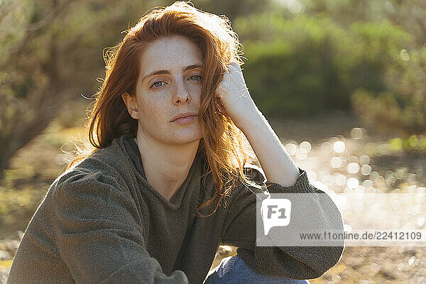 Portrait of beautiful redheaded young woman outdoors at sunset