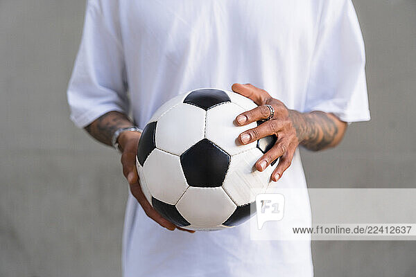 Young man s hands holding football  close-up