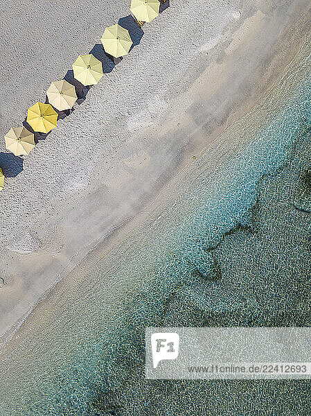 Drone view of yellow parasols arranged at beach in Bali  Indonesia