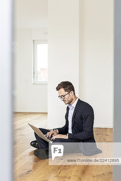 Businessman sitting on the floor using laptop