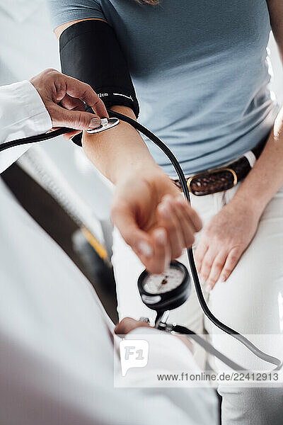 Doctor checking patient s blood pressure during a medical consultation in a clinic