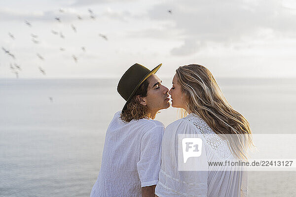 Young couple kissing in front of the sea  Ibiza  Balearic Islands  Spain
