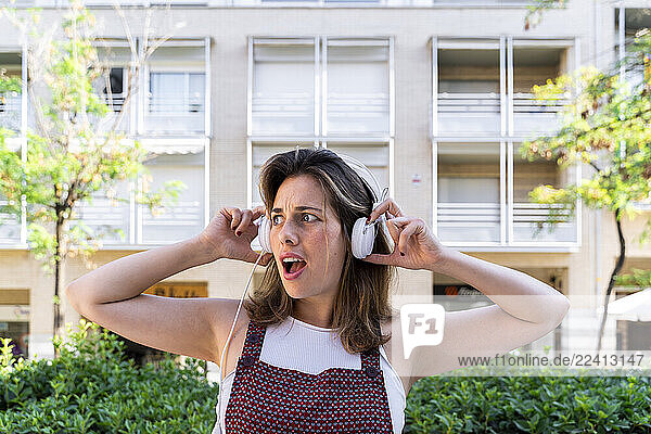 Portrait of young woman listening music  looking sideways