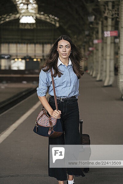 Young female traveller walking on train station