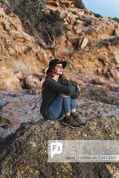 Young woman sitting on the beach and enjoying sunset  Ibiza