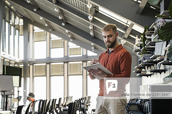Young man using a tablet in a modern office setting