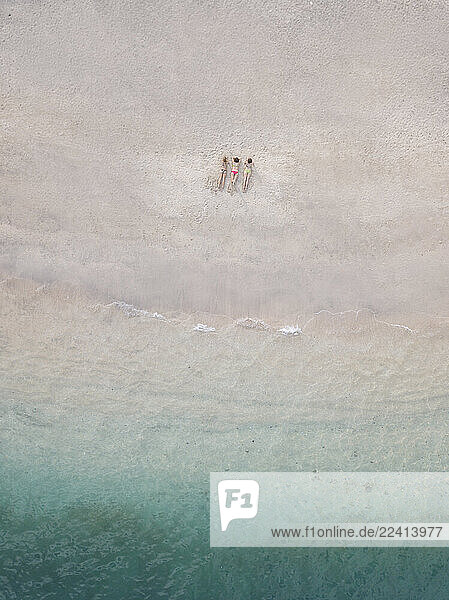 Aerial view of young women lying at the beach  Gili Air island  Bali  Indonesia