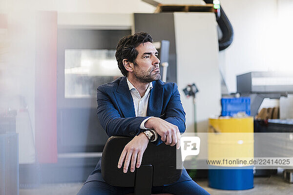 Portrait of a pensive businessman in a factory
