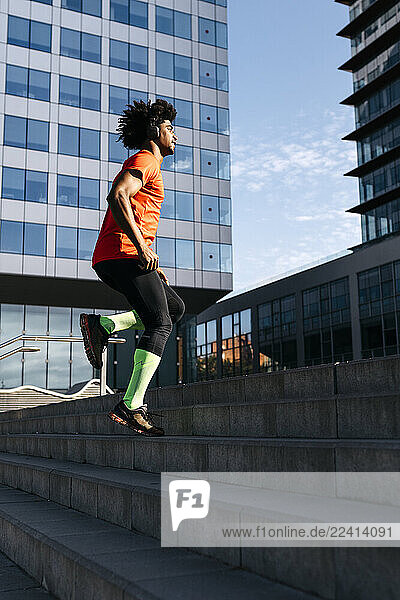 Young man jogging in the city  listening to music