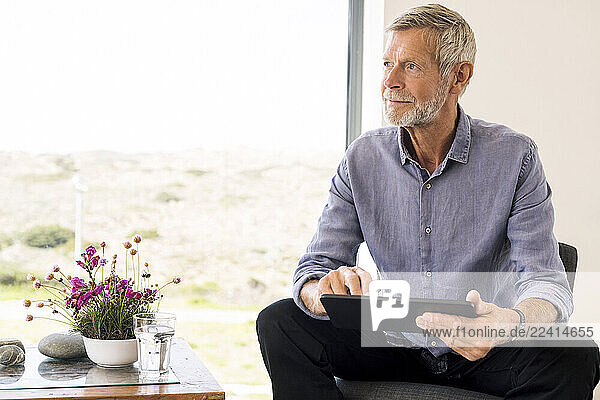 Senior man using tablet at home
