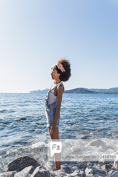 Rear view of young woman on the beach  looking at distance