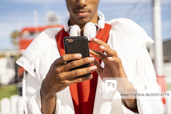 Close-up of young man using smartphone outdoors