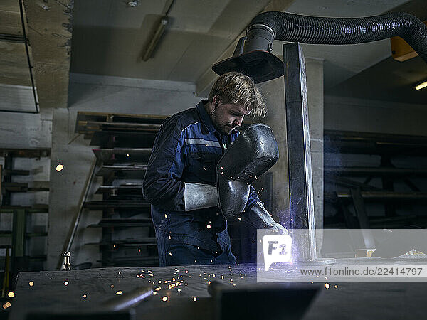 Worker welding in factory