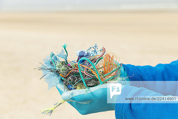 Hands holding collected ocean waste during a beach cleanup on the North Sea